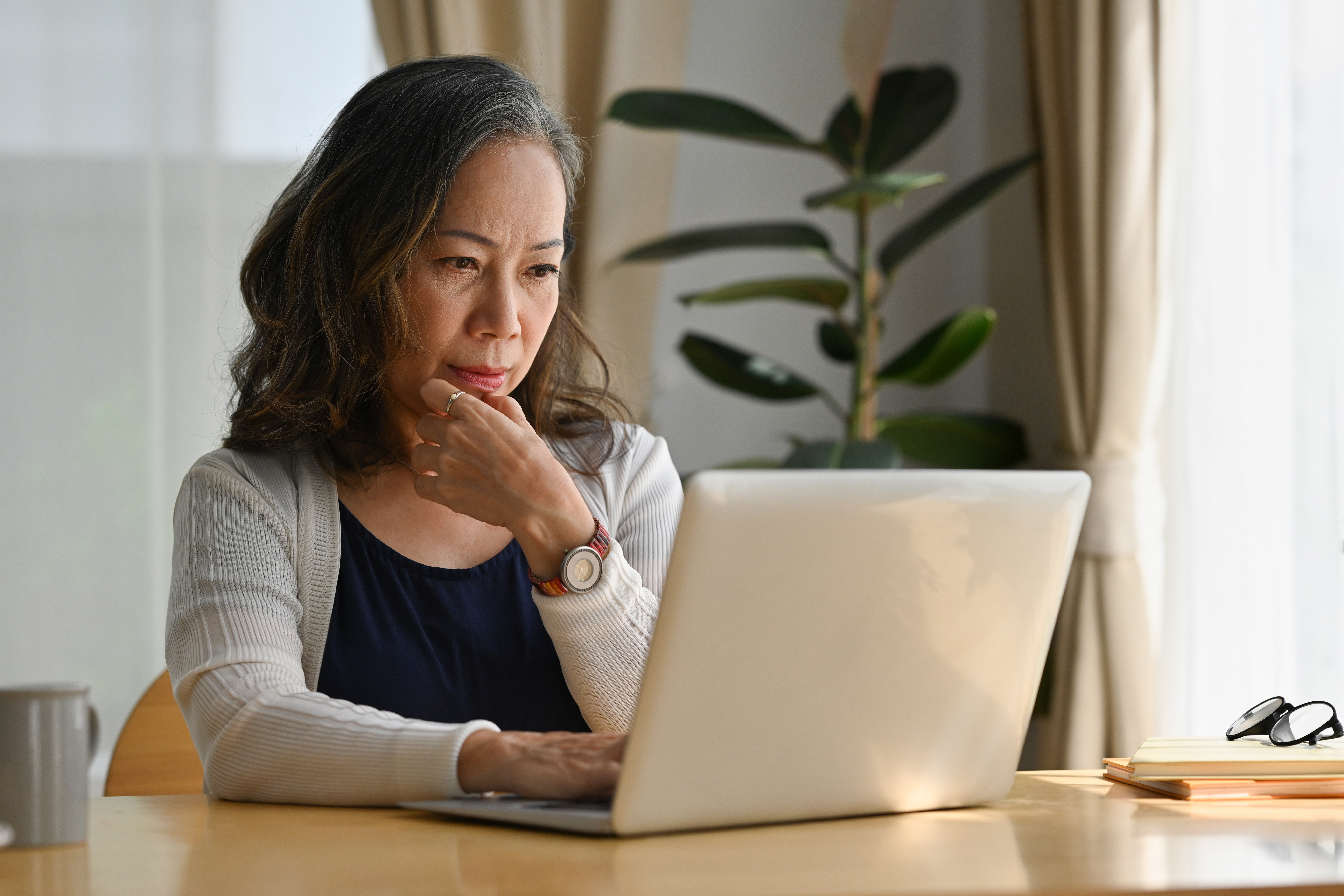 A woman searches for a new healthcare provider using a laptop.